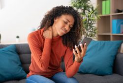 Cuidado! Postura ao usar o celular pode prejudicar a coluna. Saiba como a acupuntura pode ajudar.